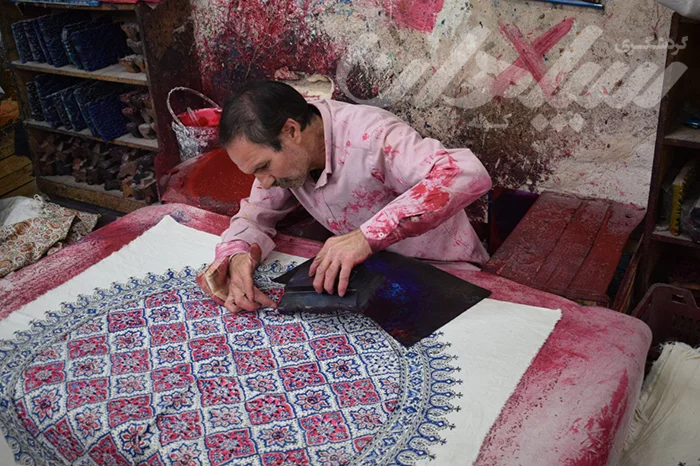 شخصی در حال نقش زدن روی پارچه قلمکاری